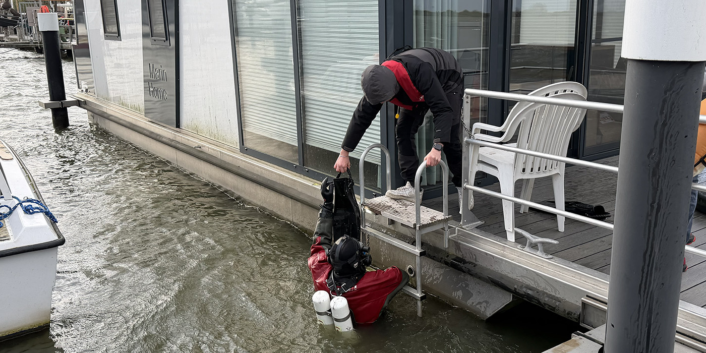De duiker kan het water uit na de controle van de anodes