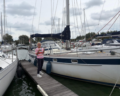 Eigenaresse bij haar zeiljacht in de jachthaven van Stellendam