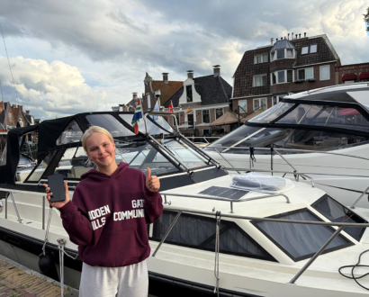 Eigenaresse met haar teruggevonden telefoon bij de boot