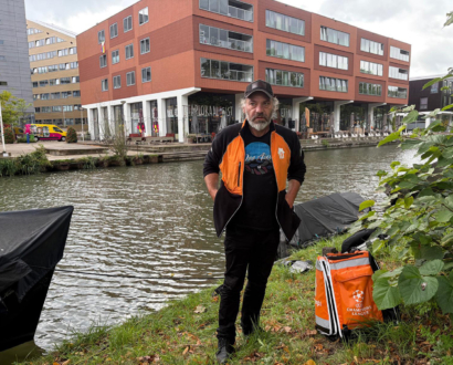 Bezorger met zijn teruggevonden telefoon aan het water