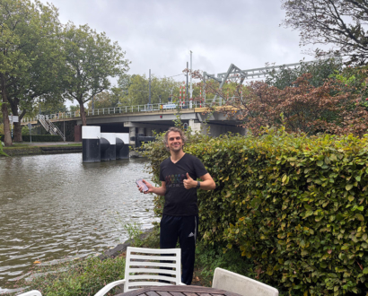 Eigenaar met zijn teruggevonden telefoon aan de gracht in Delft