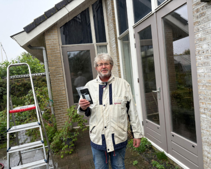 Eigenaar met zijn teruggevonden telefoon bij het huis