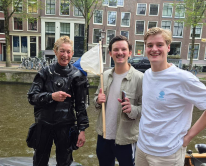 Duiker met twee eigenaren aan de gracht in Amsterdam